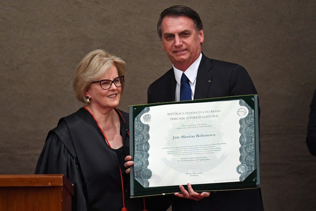 O presidente eleito, Jair Bolsonaro, recebe da presidente do Tribunal Superior Eleitoral, ministra Rosa Weber, o diploma que o habilita a assumir a Presidência â?? Foto: Evaristo Sá/AFP