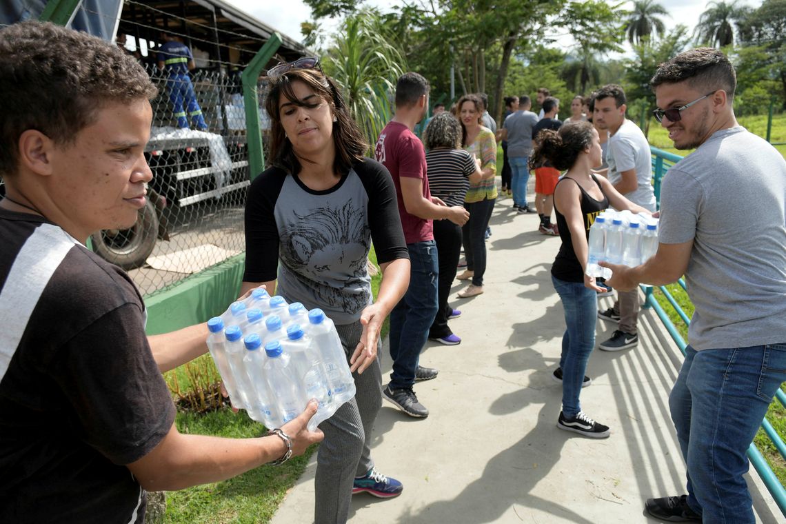 REFILE - CORRECTING GRAMMR Volunteers pass bottles of water for people affected by a failed iron ore tailings dam owned by Brazilian miner Vale SA that burst, in Brumadinho, Brazil January 27, 2019. REUTERS/Washington Alves