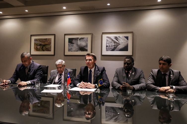 No Chile, o presidente Jair Bolsonaro faz transmissão ao vivo ao lado do porta-voz da Presidência, Rêgo Barros, do ministro Augusto Heleno (GSI), do deputado Hélio Bolsonaro e do ministro Wagner do Rosário (Transparência e CGU).