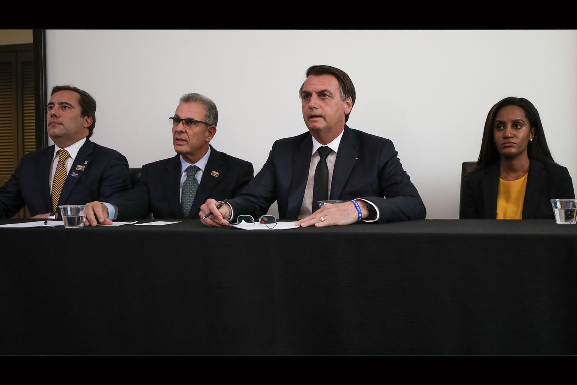 O presidente Jair Bolsonaro, em Dallas (EUA), faz transmissão ao vivo para as redes sociais. ao lado do presidente da Caixa, Pedro Guimarães, do ministro de Minas e Energia, Bento Albuquerque, e da intérprete de libras, Joyce Porto.