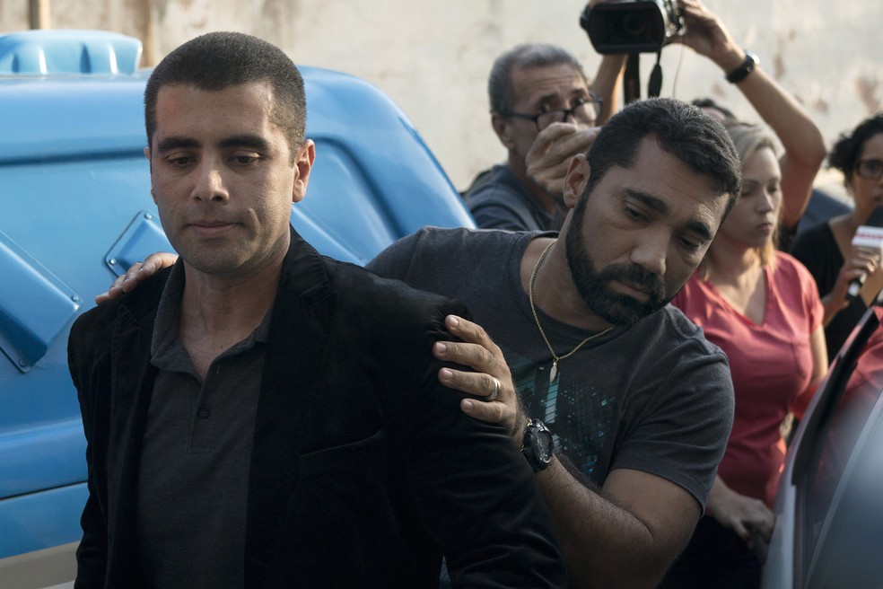O mÃ©dico Denis Cesar Barros Furtado, o Dr. Bumbum, Ã© escoltado pela polÃ­cia apÃ³s prisÃ£o no Rio de Janeiro (Foto: Leo Correa/AP)