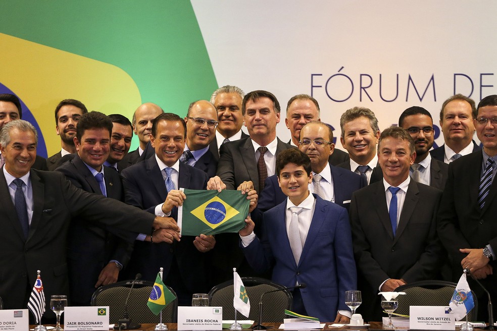 O presidente eleito Jair Bolsonaro posa com uma bandeira do Brasil entre governadores eleitos e reeleitos para o mandato que se inicia em 2019, durante o Fórum de Governadores em BrasÃlia â?? Foto: Marcelo Camargo/Agência Brasil