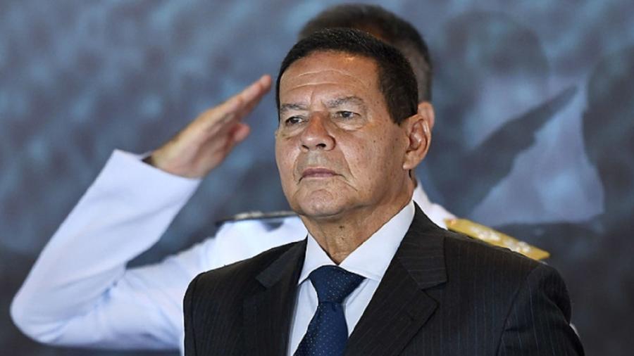 Hamilton Mourão, vice-presidente, à frente de um militar que presta continência - Evaristo Só/AFP