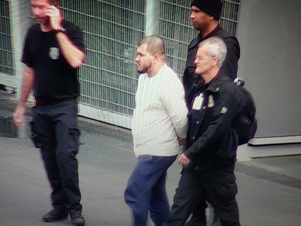 Reprodução de vídeo mostra agentes da Polícia Federal (PF) conduzindo um dos suspeitos presos na Operação Hashtag, no Aeroporto Intercional de Guarulhos, na Grande São Paulo, nesta quinta-feira  (Foto: Mario Angelo/Sigmapress/Estadão Conteúdo)