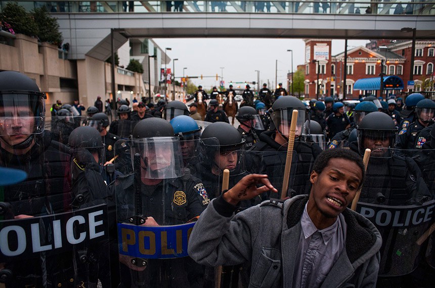 epa04720846 A protestor reacts as he stands in front of police officers during a demonstration outside of Camden Yards to protest the death of Freddie Gray in Baltimore, Maryland, USA, 25 April 2015. Gray died of spinal cord injuries on 19 April while in police custody; the US Justice Department announced that they are launching their own investigation into the case. EPA/NOAH SCIALOM