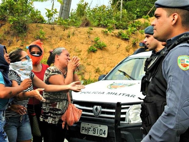 Familiares de presos cobrem rostos e pedem informações de policiais do lado de fora do Compaj, em Manaus (Foto: Isis Capistrano / G1 AM)