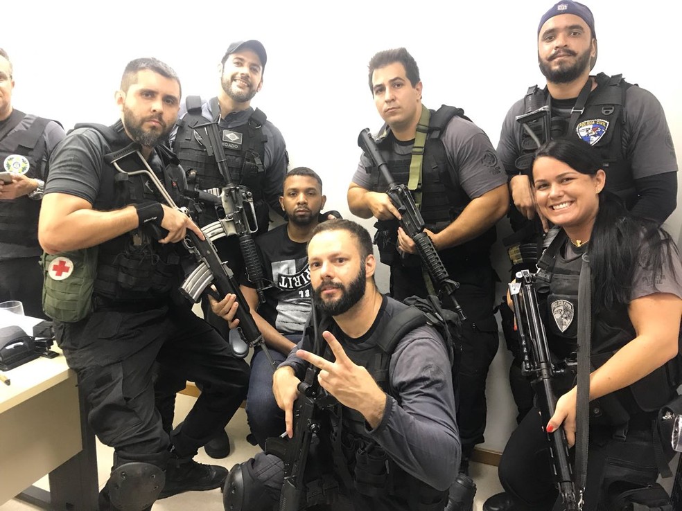 Agentes são fotografados ao lado de criminoso (Foto: Redes sociais)