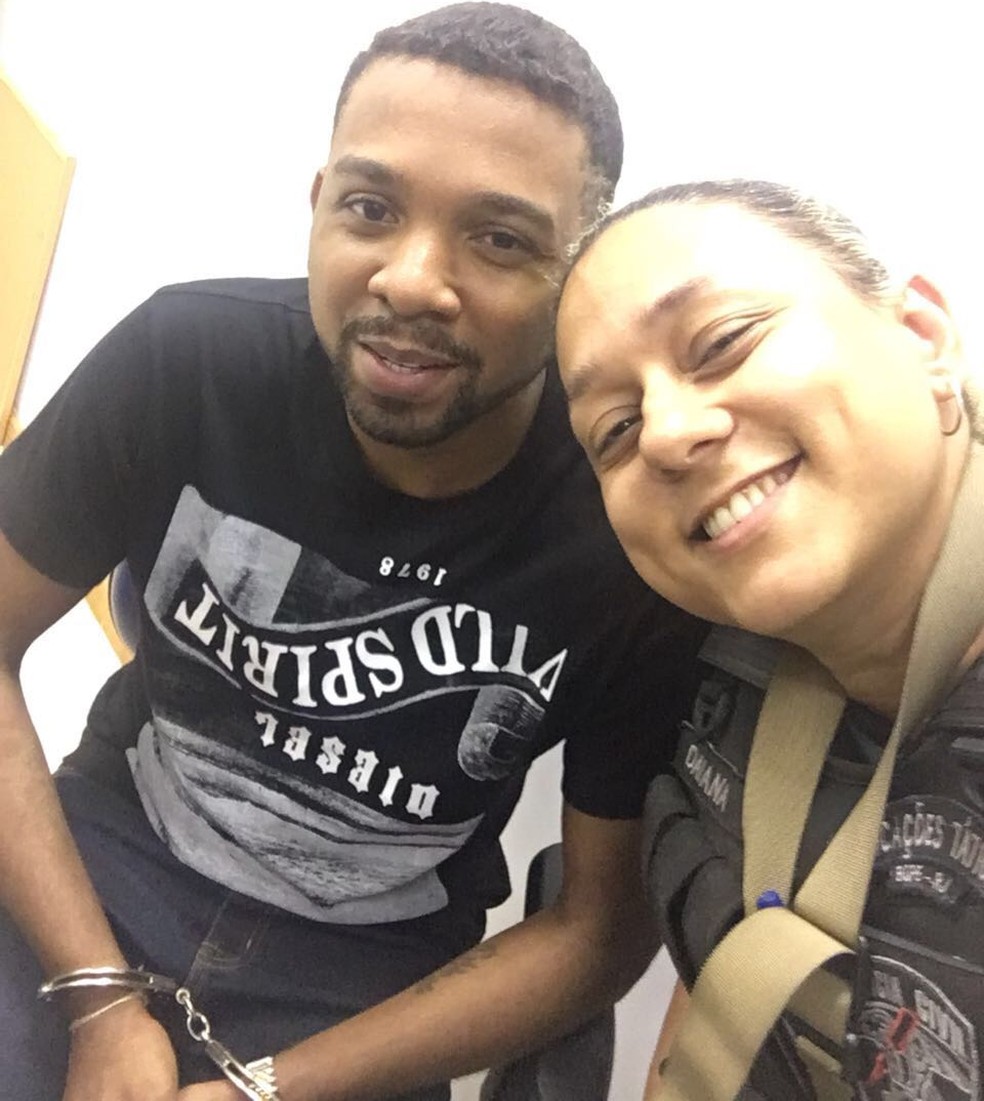 Algemado e sorridente, Rogério 157 posa para selfie com policial (Foto: Redes sociais)