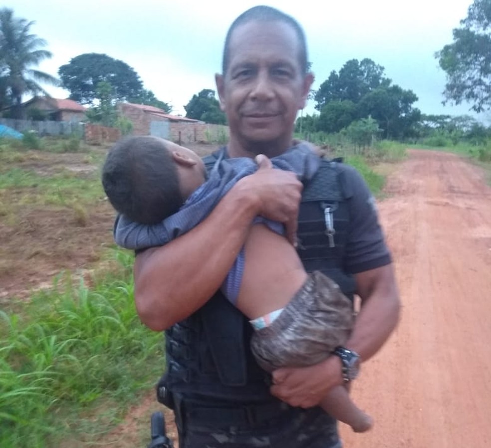 Policial Adilson de Figueiredo, do GOE, segura uma das crianças que foi resgatada em Nova Lacerda â?? Foto: Gerência de Operações Especiais (GOE)